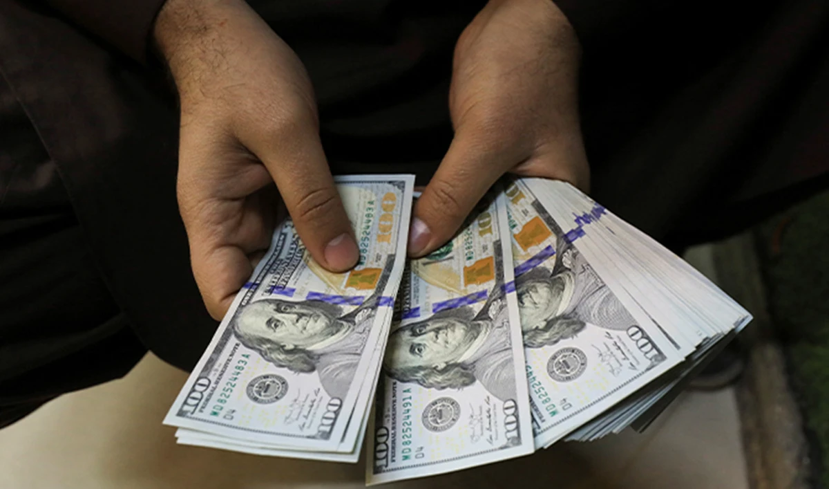 A trader counts U.S. dollar banknotes at a currency exchange booth in Peshawar, Pakistan, on January 25, 2023. (Reuters/File)