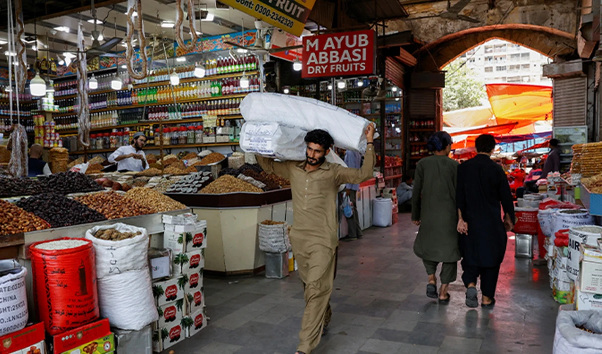 A man walks with sacks of supplies on his shoulder to deliver to a nearby shop at a market in Karachi, Pakistan June 11, 2024. (Reuters/File)