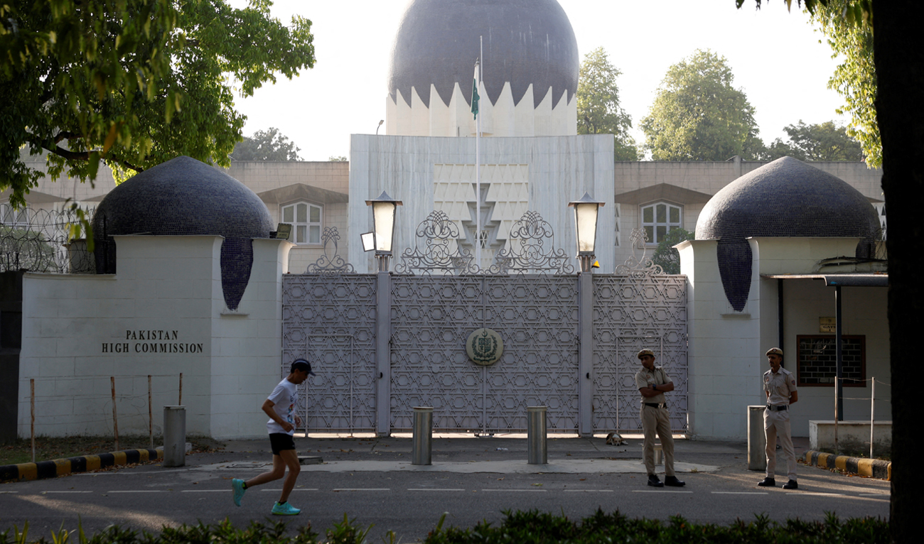 A man jogs past policemen standing outside the gate of Pakistan High Commission in New Delhi, India on April 24, 2025. (REUTERS)
