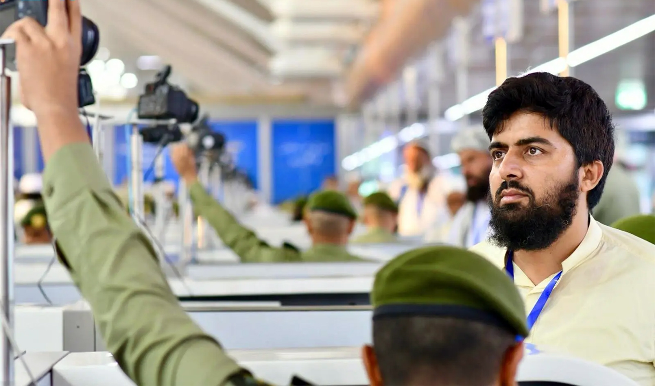 Saudi official takes a photograph of a Pakistani pilgrim at the Prince Mohammed bin Abdulaziz International Airport in Madinah on May 1, 2025. (SPA)