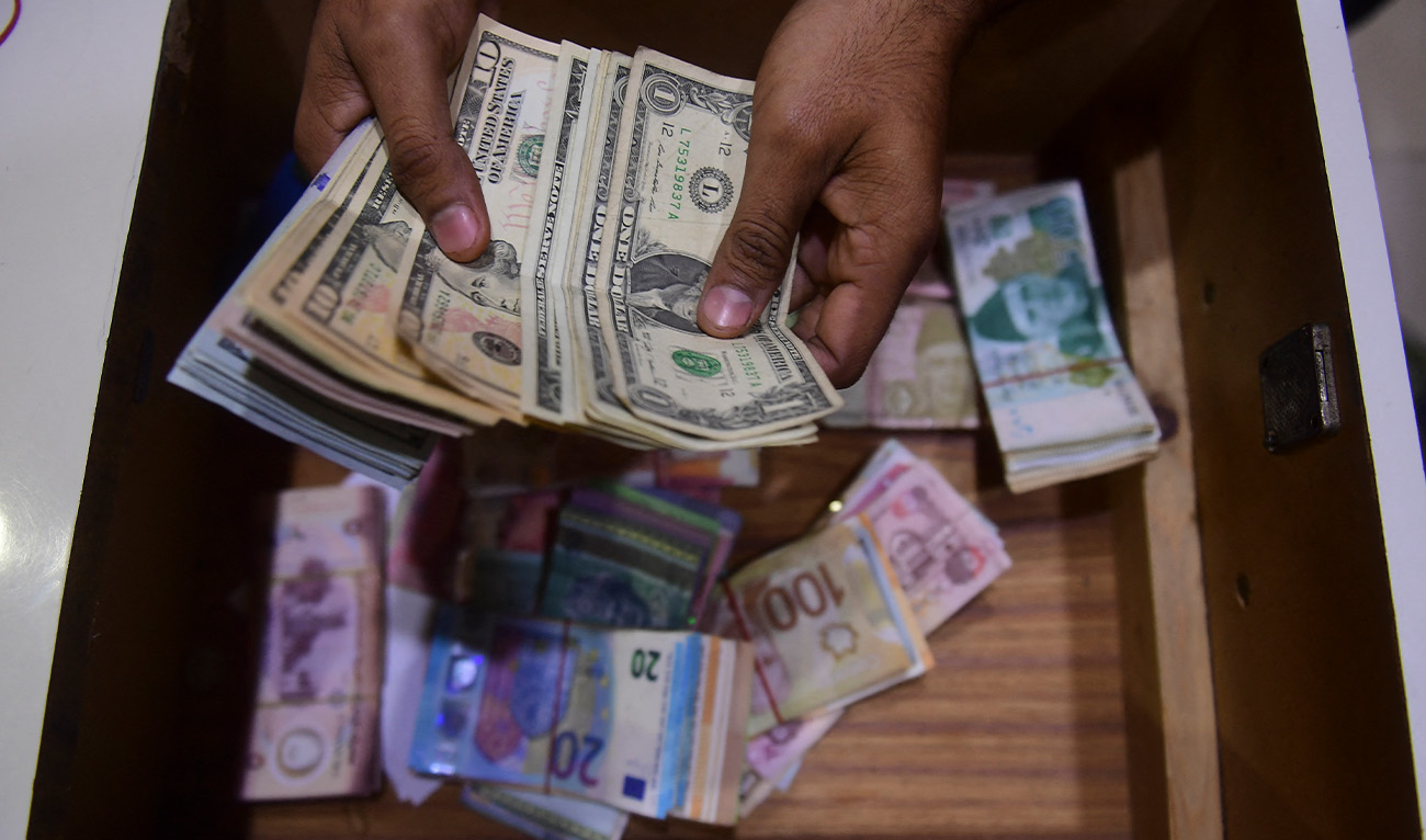 A dealer counts US dollars at a money exchange market in Karachi on January 27, 2023. (AFP/File)