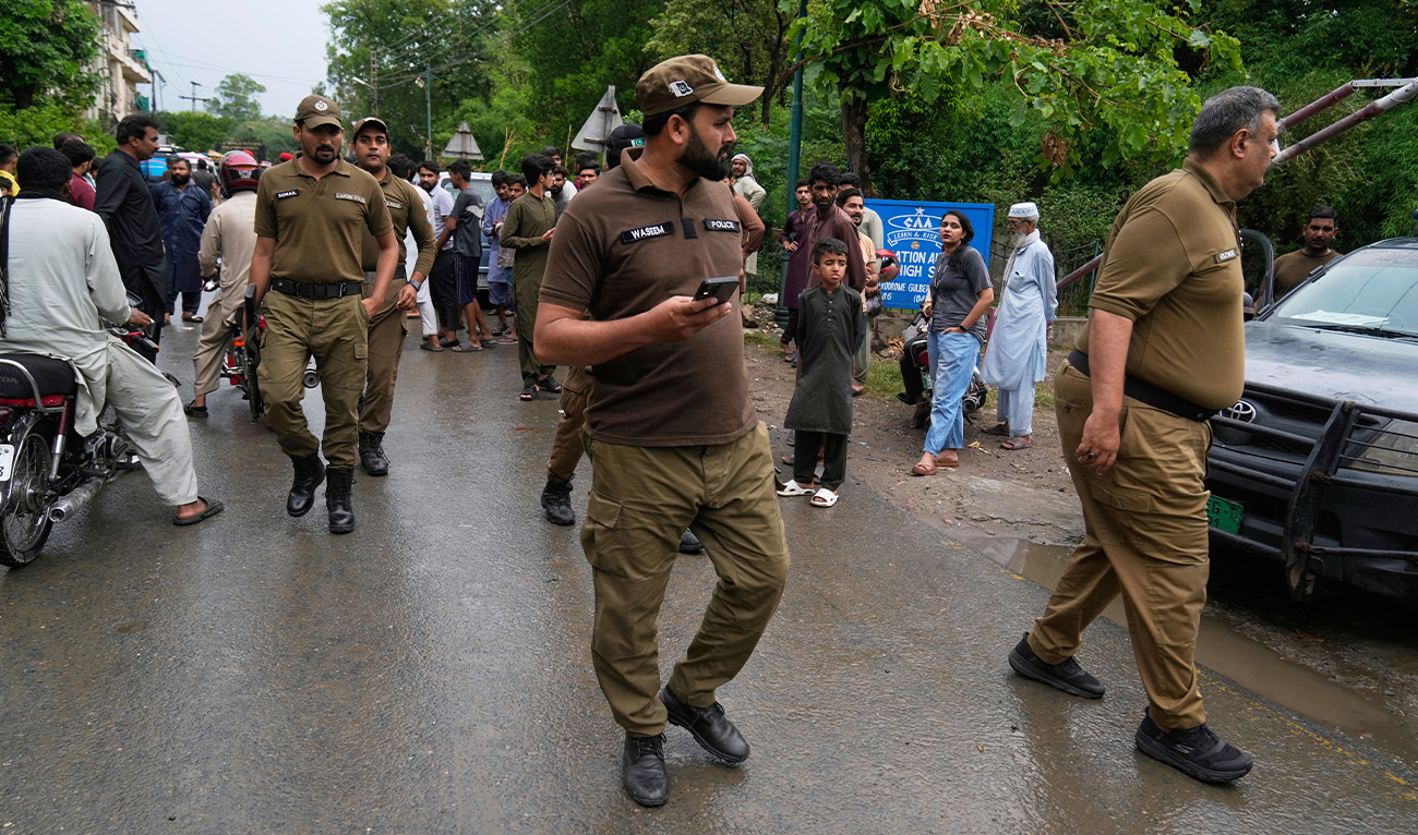 Police officers arrive to control crowd gathered at an entry point to a garrison area, where a suspected Indian drone crashed in Lahore, Pakistan, on May 8, 2025. (AP)