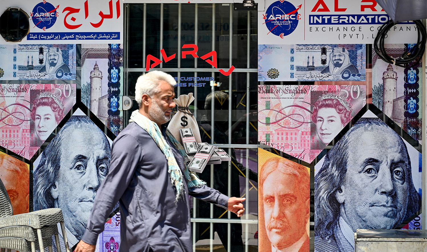 A man walks past a currency exchange shop in Rawalpindi on June 12, 2024. (AFP/File)