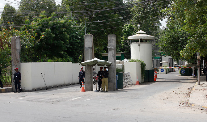 A policeman (2nd R) and private security personnel stand guard at the entrance of a road leading towards the U.S. consulate in Lahore August 9, 2013. (Reuters/File)