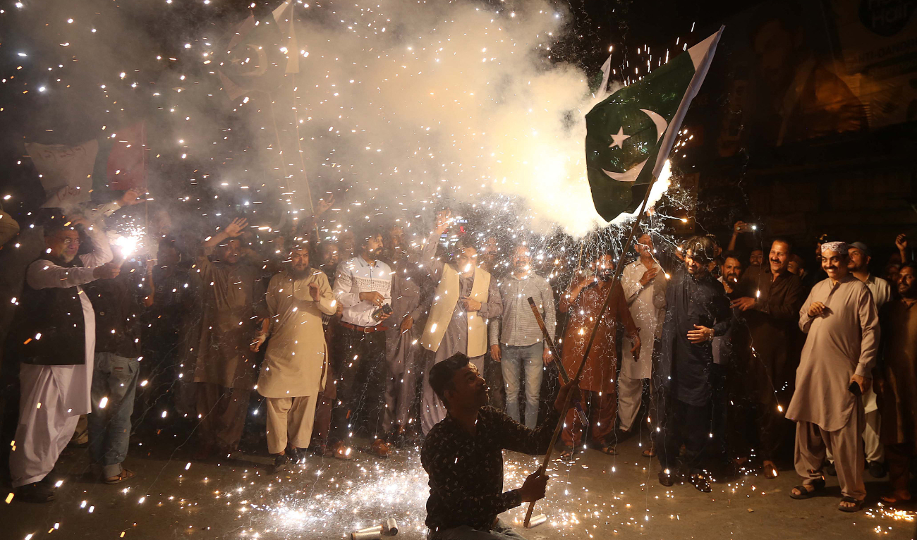 A Pakistani man waves the national flag as people celebrate after the ceasefire between Pakistan and India, in Hyderabad, Sindh province, on May 10, 2025. (AFP)