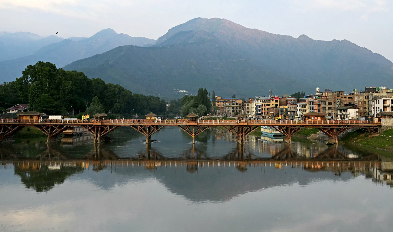 A reflection of a walkover bridge shimmers over Jhelum river in Srinagar on May 10, 2025. (AFP)
