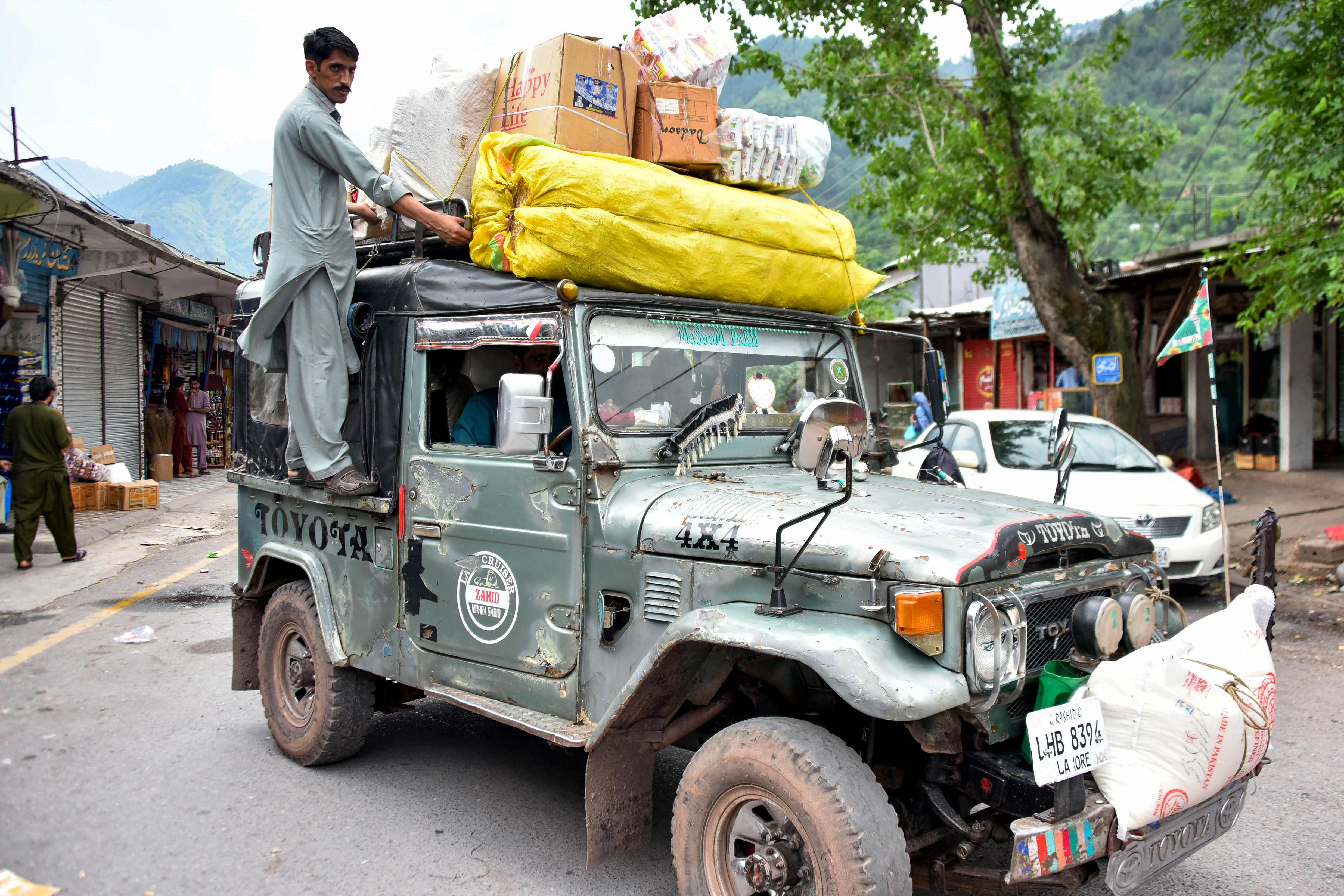 Residents ride a vehicle loaded with food and supplies as market reopened after Pakistan-India ceasefire at the frontier village of Chakothi near the Line of Control (LoC), in Pakistan-administered Kashmir on May 11, 2025. (AFP)
