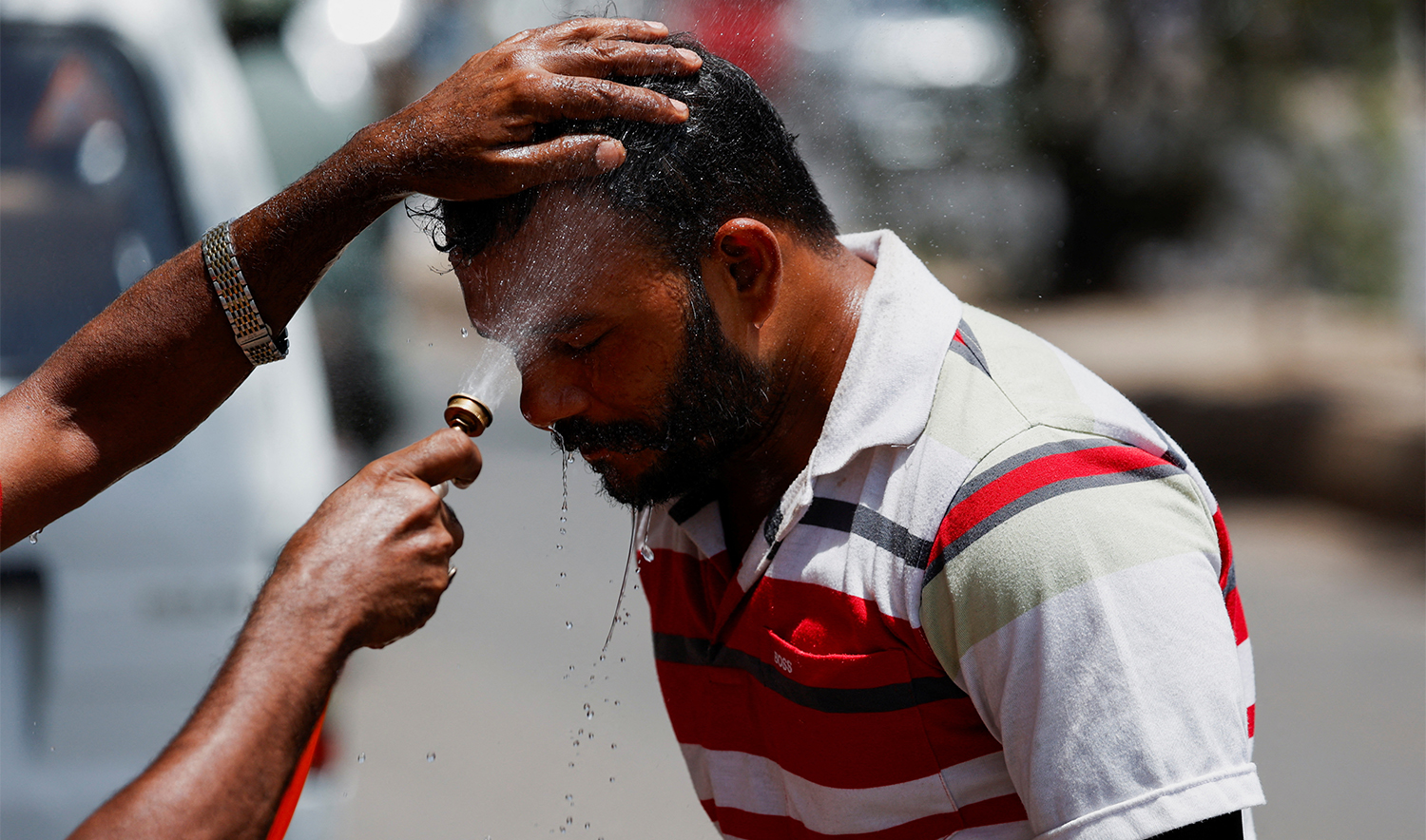 A man receives a spray of cold water to avoid heat during a hot day, along a road in Karachi, Pakistan, on April 22, 2025. (REUTERS/File)