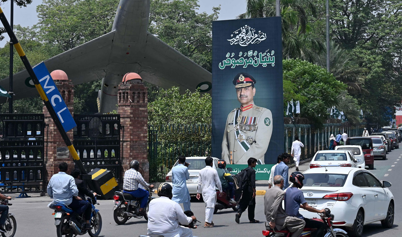 Commuters ride past a poster featuring Pakistani Army Chief General Syed Asim Munir, along a road in Lahore on May 16, 2025. (AFP)