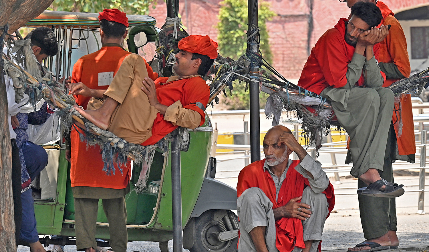 Porters rest under a tree near Lahore railway station in Lahore on May 21, 2025, on a hot summer day. (AFP)
