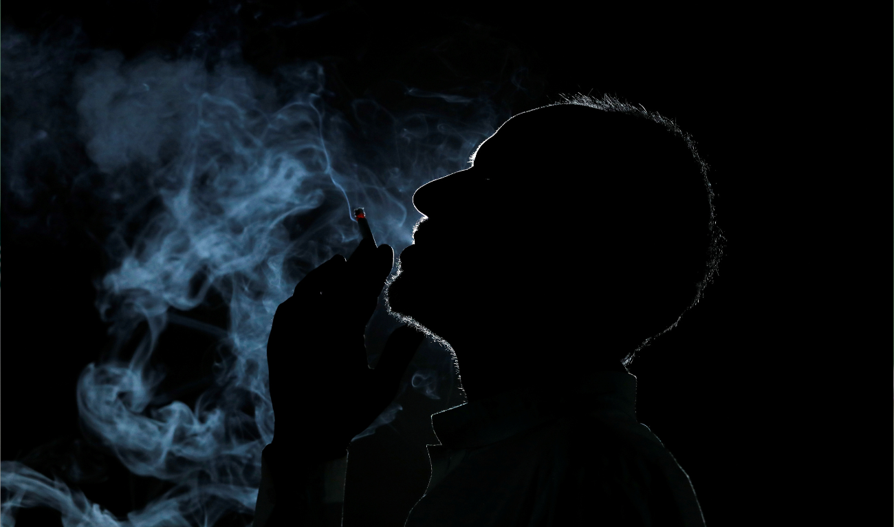 A man is seen in silhouette as he smokes a cigarette at his shop in Peshawar, Pakistan May 28, 2019. (REUTERS/ file)