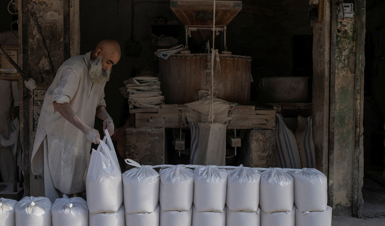 A shopkeeper arranges bags of milled whole grain flour for sale in Rawalpindi, Pakistan on May 20, 2025. (REUTERS)