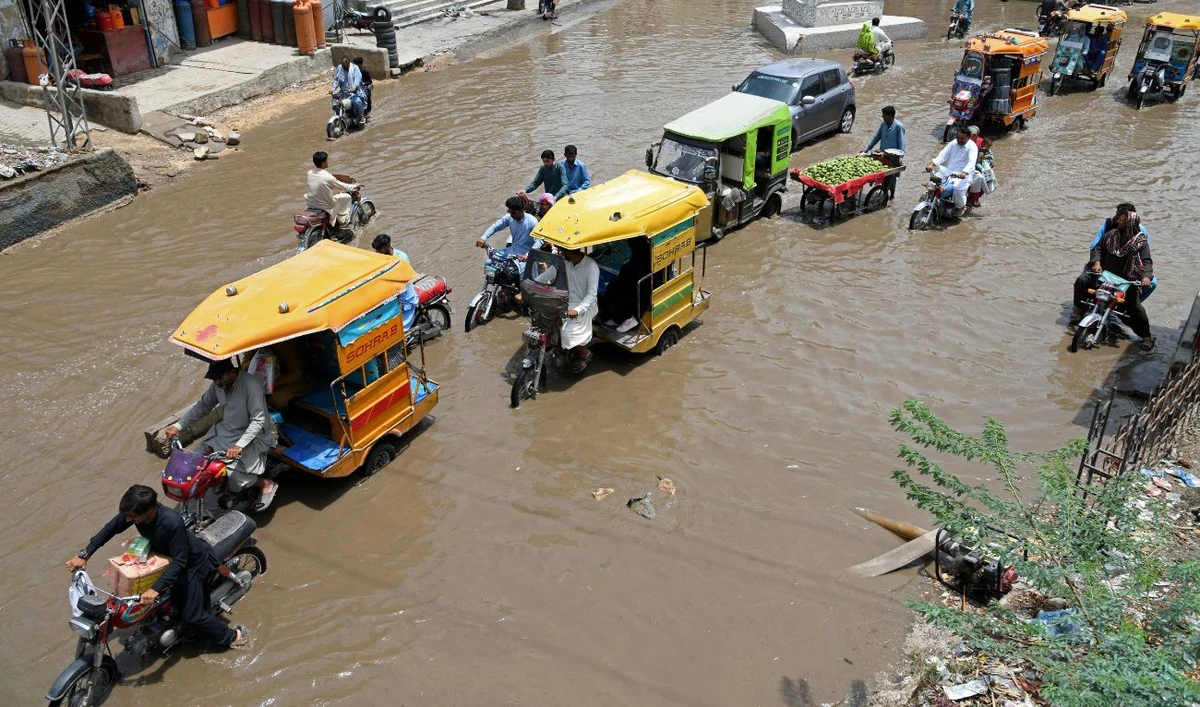 Commuters drive through a flooded street after heavy rain in Larkana, Sindh province on May 5, 2025. (AFP)