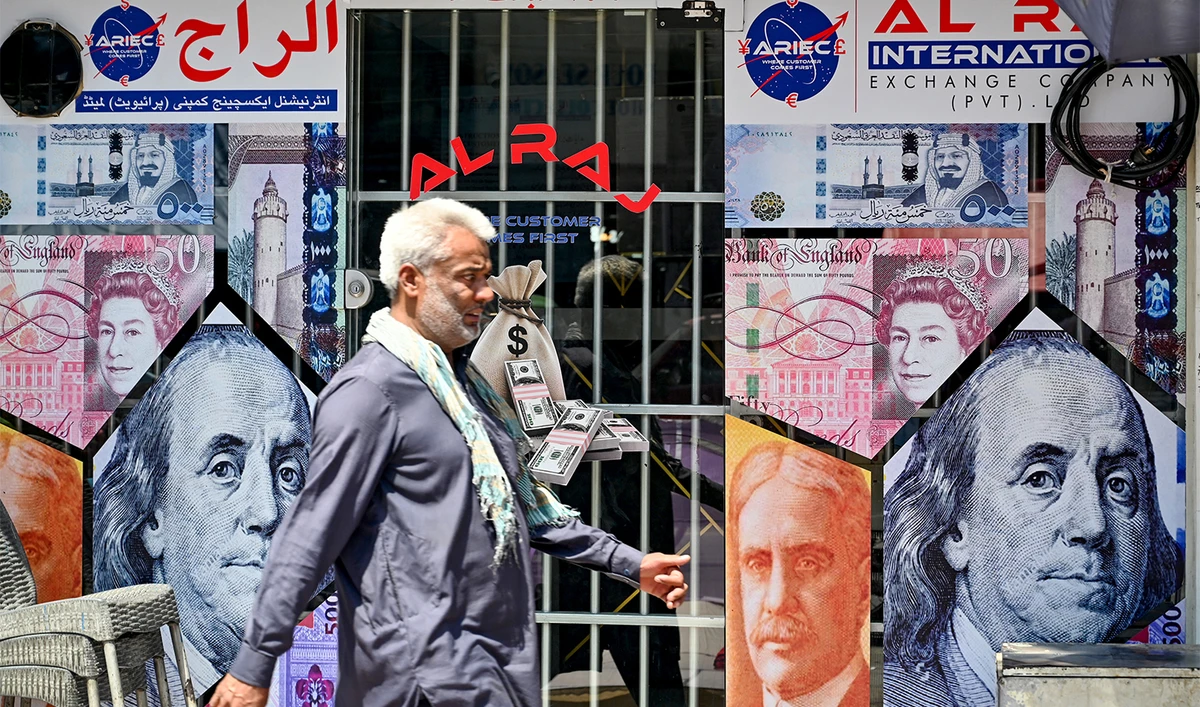 A man walks past a currency exchange shop in Rawalpindi on June 12, 2024. (AFP/File)