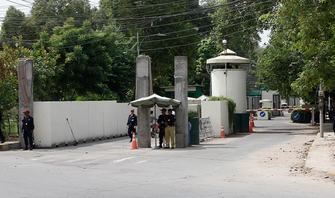 A policeman (2nd R) and private security personnel stand guard at the entrance of a road leading towards the U.S. consulate in Lahore August 9, 2013. (Reuters/File)