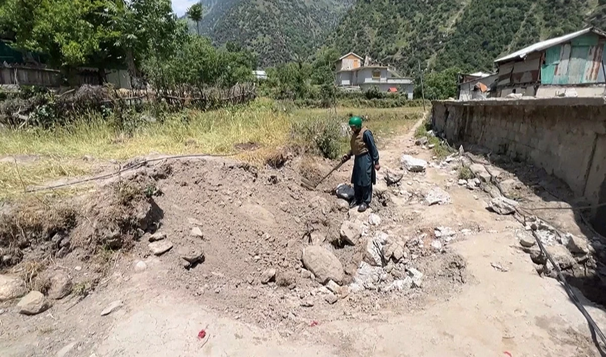 Member of clearance team combs through rubble with a metal detector to look for unexploded shells in Neelum Valley, Pakistan, on May 19, 2025. (AFP)