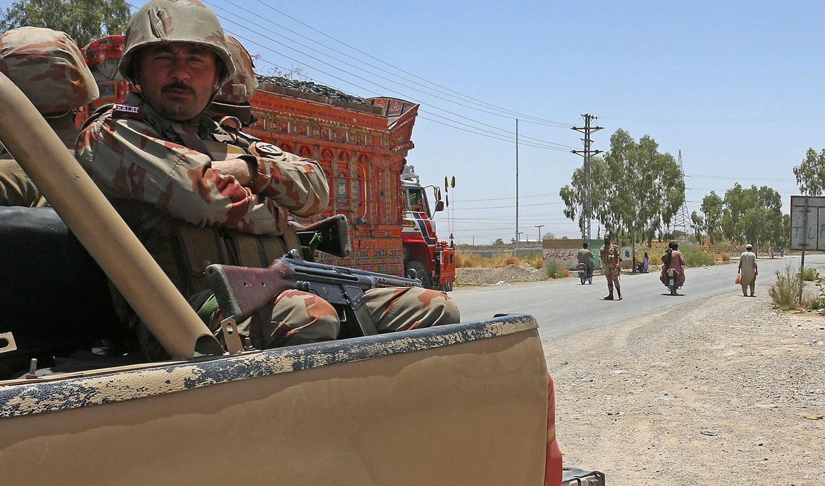 Security personnel guard along a street near the site of a school bus bombing in the Khuzdar district of Balochistan province on May 21, 2025. (AFP)