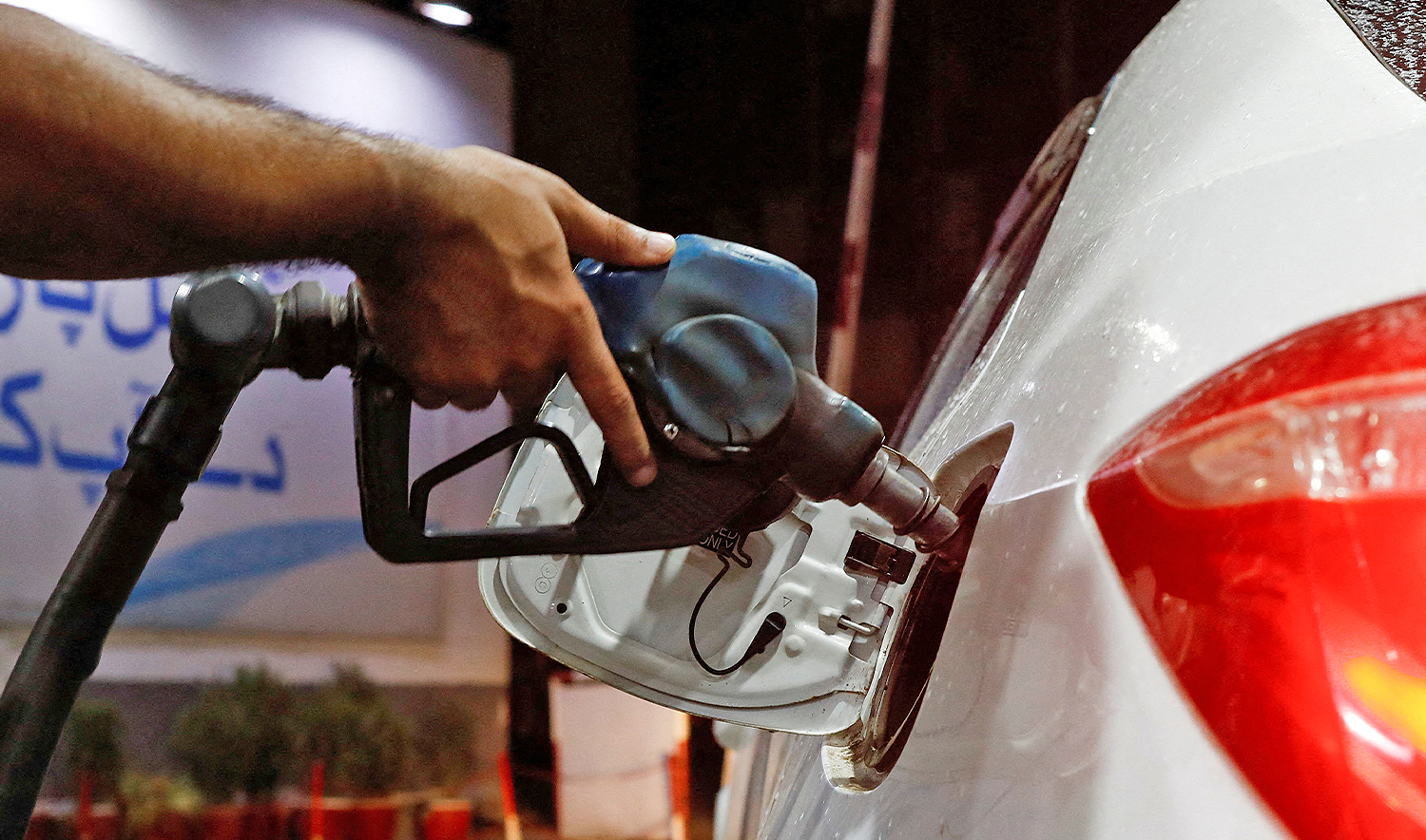 A worker holds a fuel nozzle to fills fuel in a car, after the government announced the increase of petrol and diesel prices, at petrol station in Karachi, Pakistan, on September 16, 2023. (REUTERS/File)