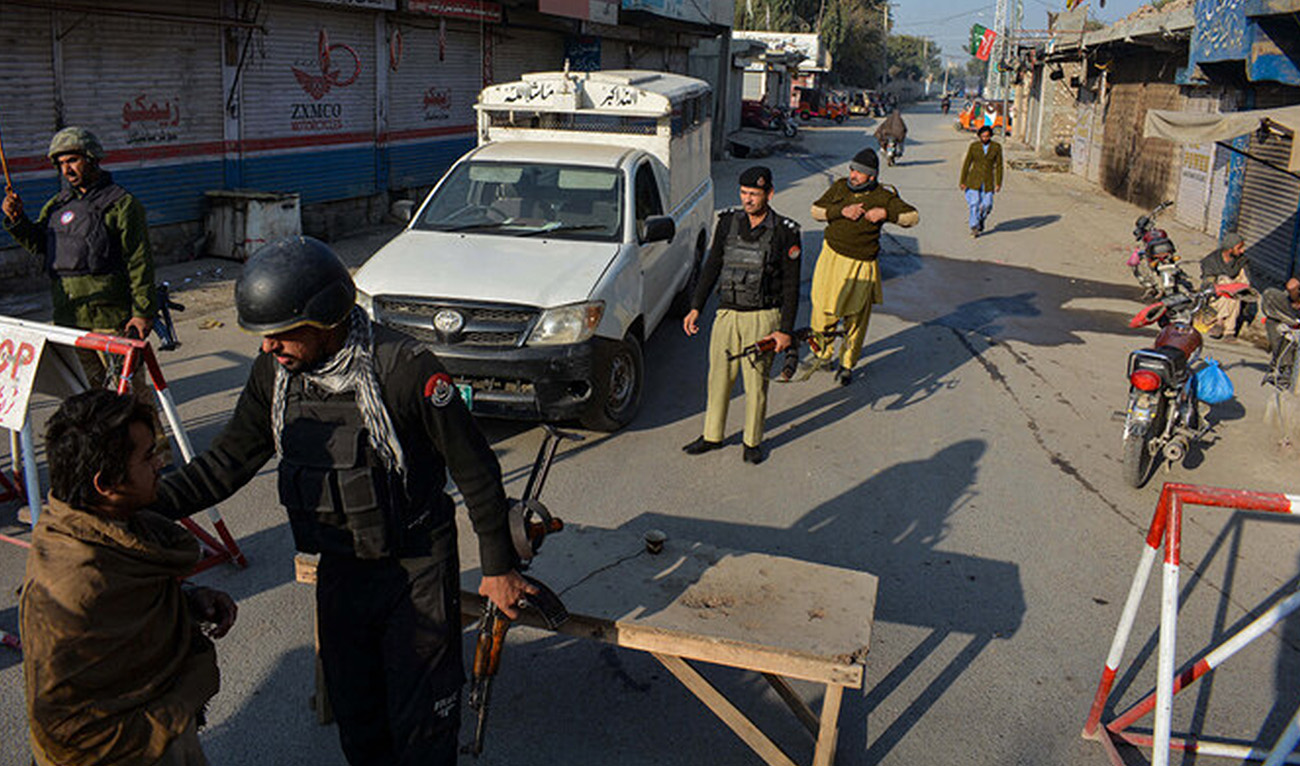 Police stand guard along a road they blocked after militants seized a police station in Bannu, Pakistan, on December 19, 2022. (AFP/File)
