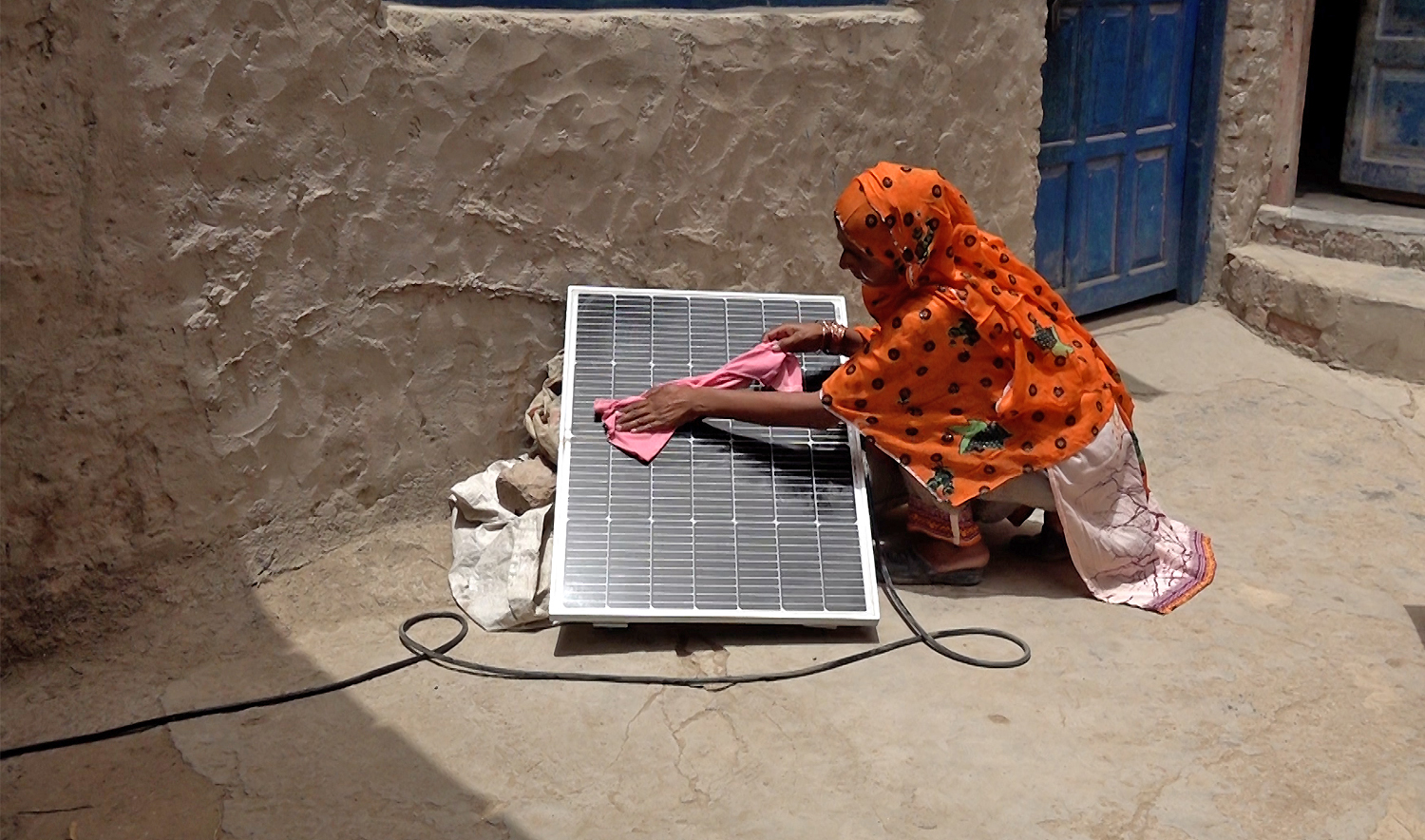 A woman wipes out dust from a solar panel at her house in Karachi, Pakistan, on May 27, 2025. (AN photo)
