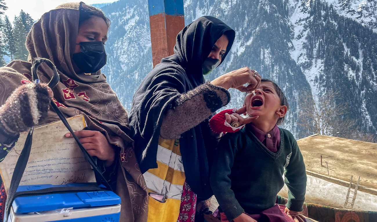 A health worker administers polio drops to a child during a door-to-door vaccination campaign amidst heavy snow in the Bakwali-Surgan area of Pakistan-administered Kashmir's Neelum Valley, on February 4, 2025. (AFP/File)