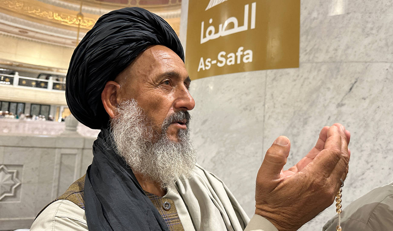 A Muslim pilgrim prays near a sign indicating the way to Al-Safa mountain, at the Grand Mosque in the Saudi holy city of Mecca on June 7, 2025, at the end of the annual Hajj pilgrimage (AFP)