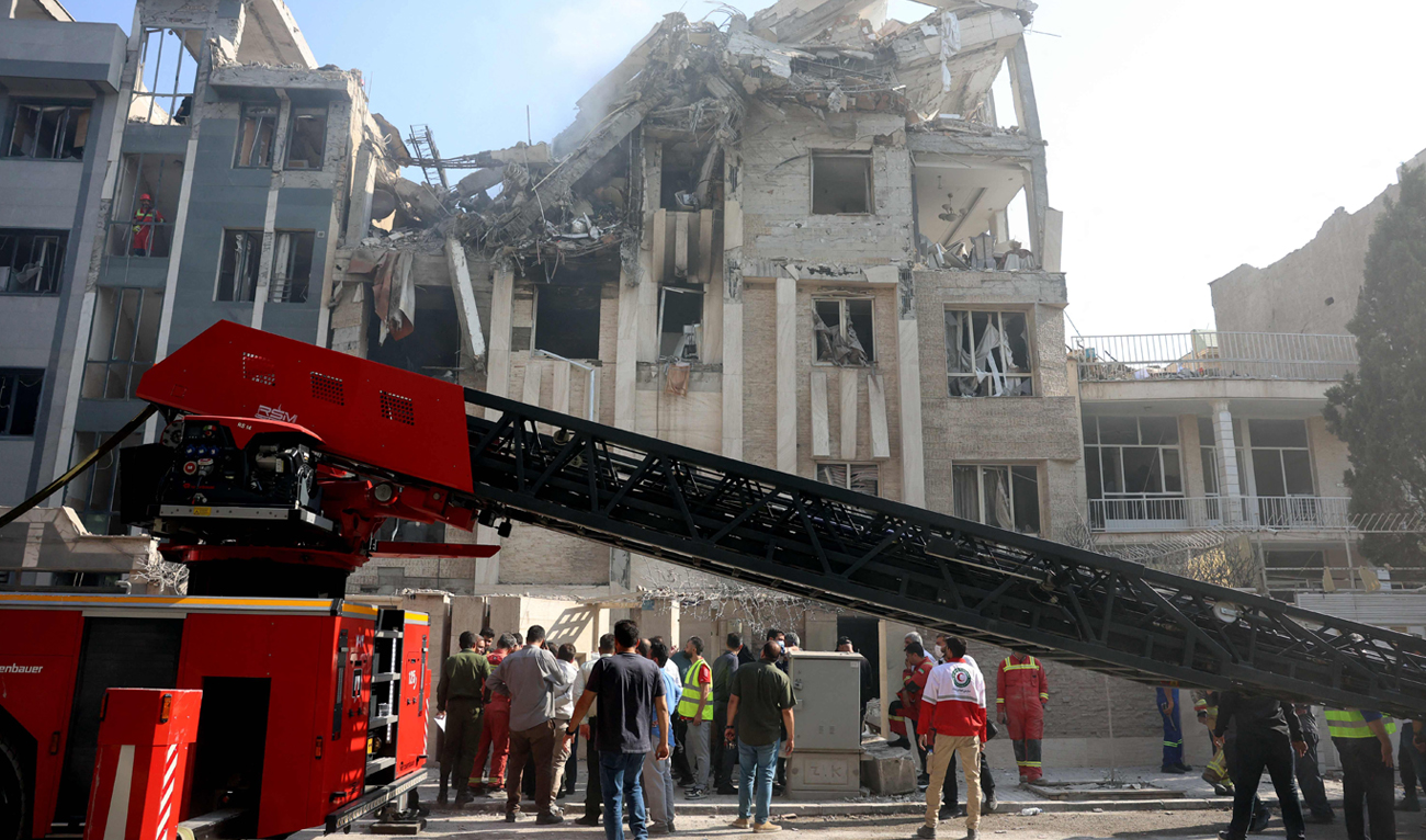 Rescue teams work outside a heavily damaged building, targeted by an Israeli strike in the Iranian capital Tehran on June 13, 2025. (AFP)