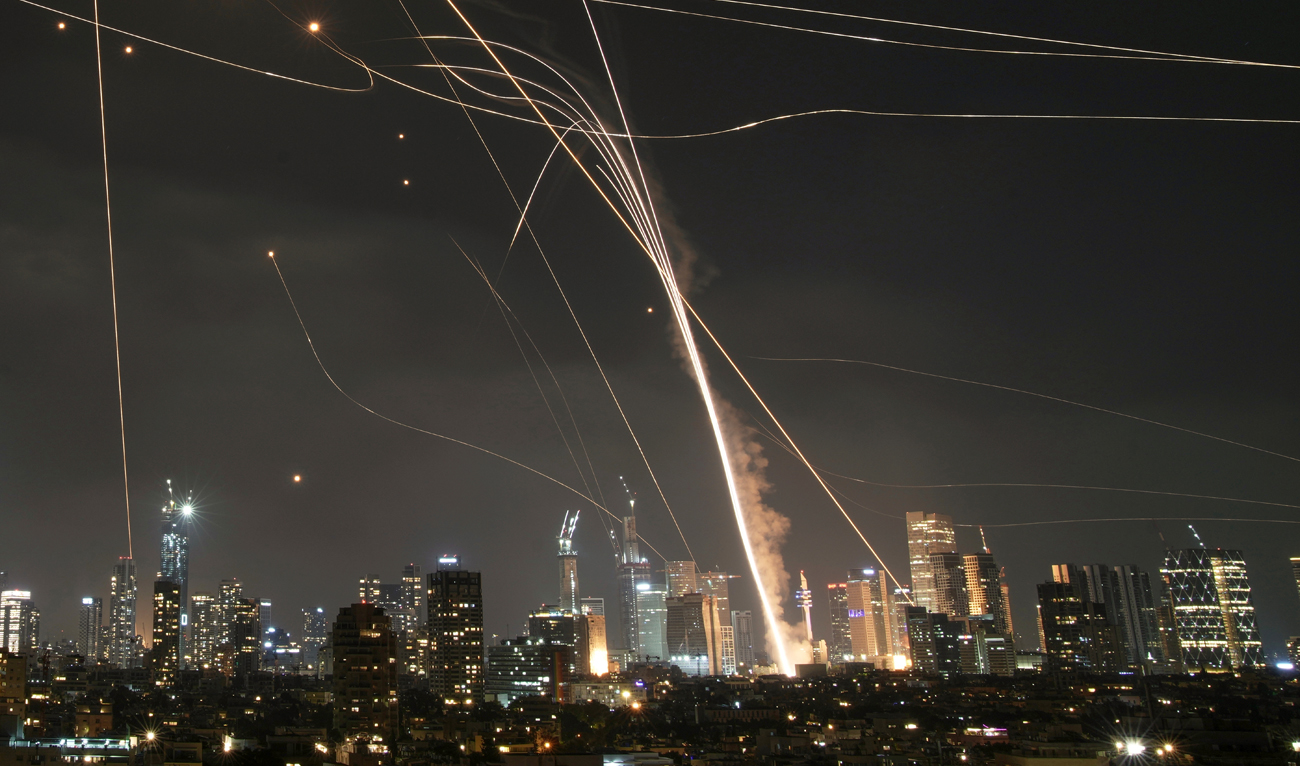 A projectile hit buildings as Israeli Iron Dome air defense system fires to intercept missiles over Tel Aviv, Israel on June 13, 2025. (AP)