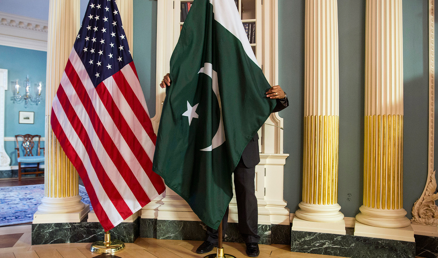 A State Department contractor adjust a Pakistan national flag before a meeting between U.S. Secretary of State John Kerry and Pakistan's Interior Minister Chaudhry Nisar Ali Khan on the sidelines of the White House Summit on Countering Violent Extremism at the State Department in Washington on February 19, 2015. (REUTERS/File)