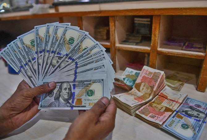 A foreign currency dealer counts US dollars at a shop in Karachi, Pakistan, on May 19, 2022. (AFP/ file)