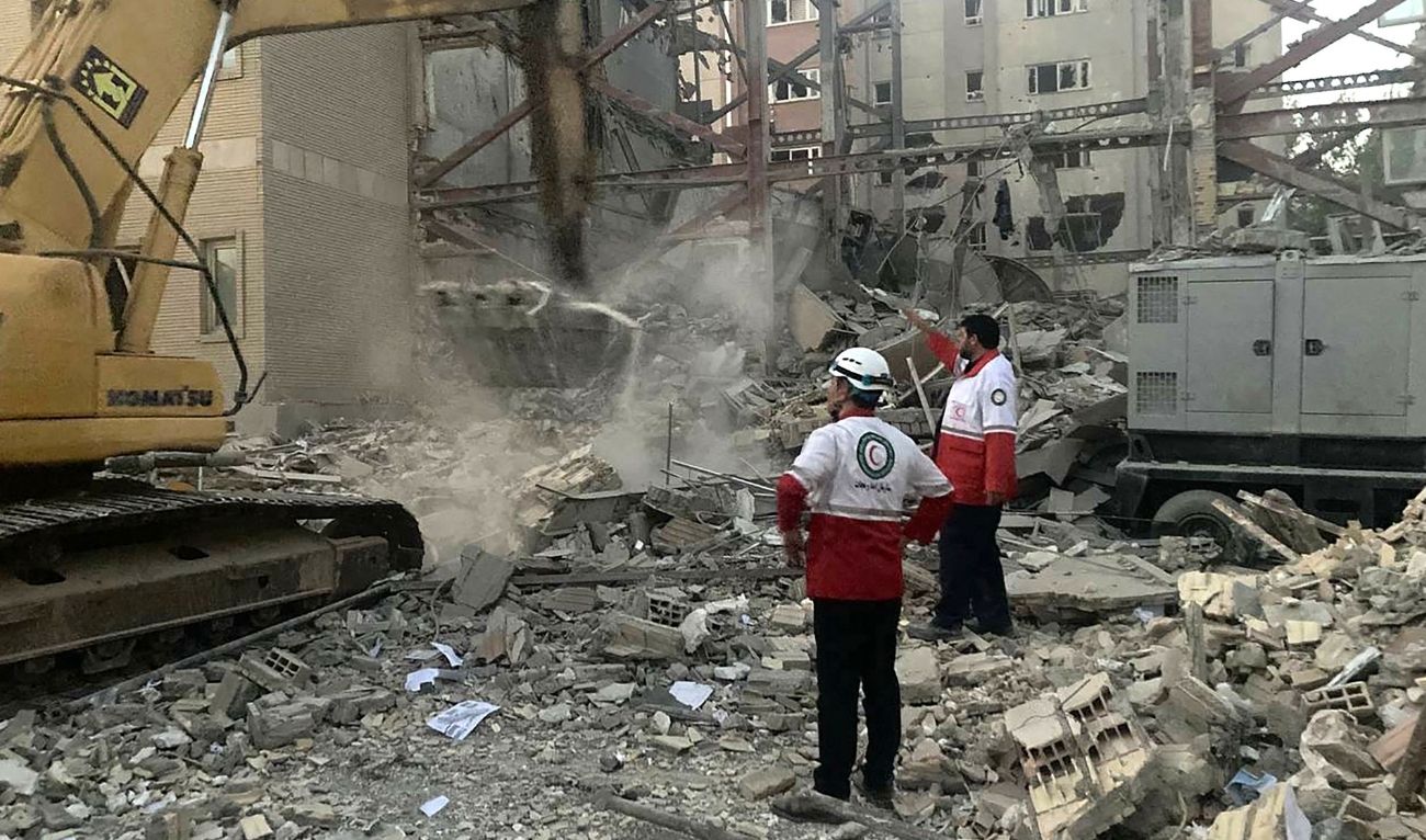 This handout picture provided by the Iranian Red Crescent on June 19, 2025 shows members of their rescue teams clearing debris at a building destroyed during an Israeli attack in Tehran. (AFP)