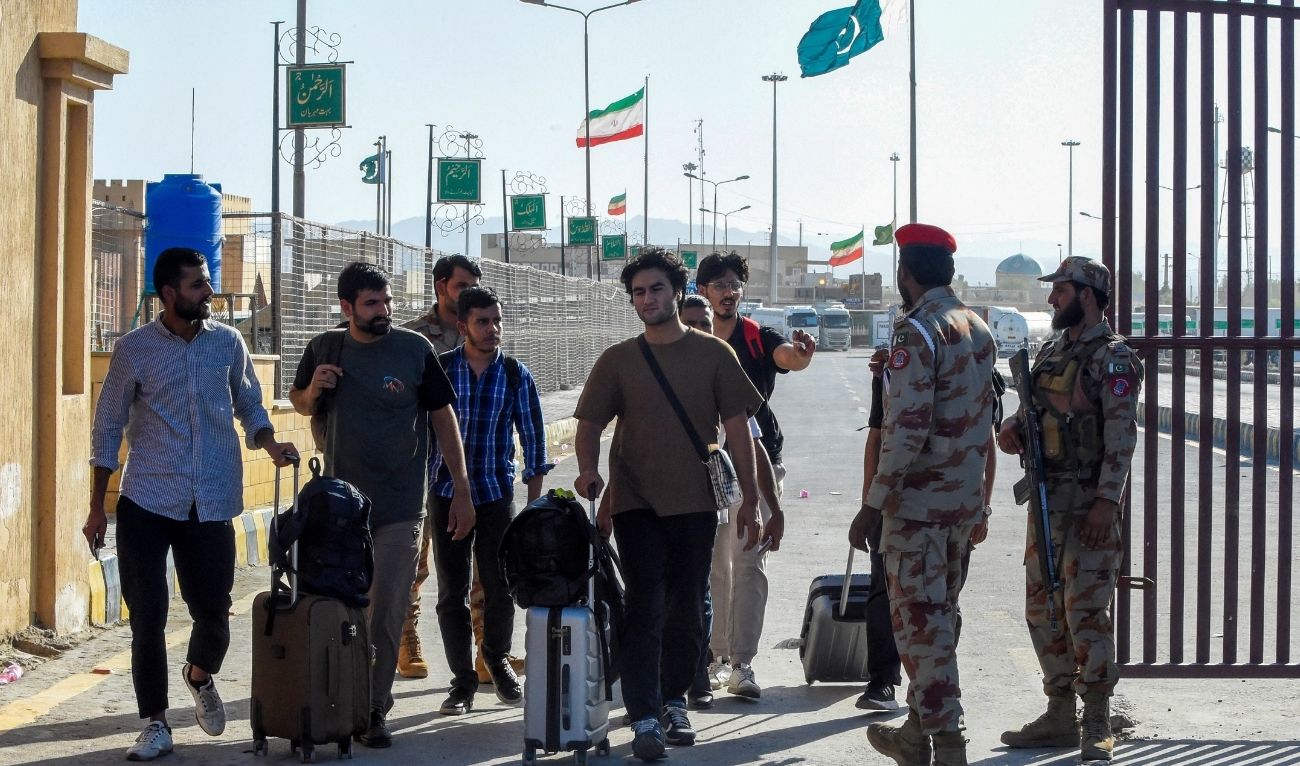 Pakistani students evacuated from Iran walk across the Pakistan-Iran border at Taftan, in Balochistan province on June 18, 2025, amid the ongoing conflict between Israel and Iran. (AFP)