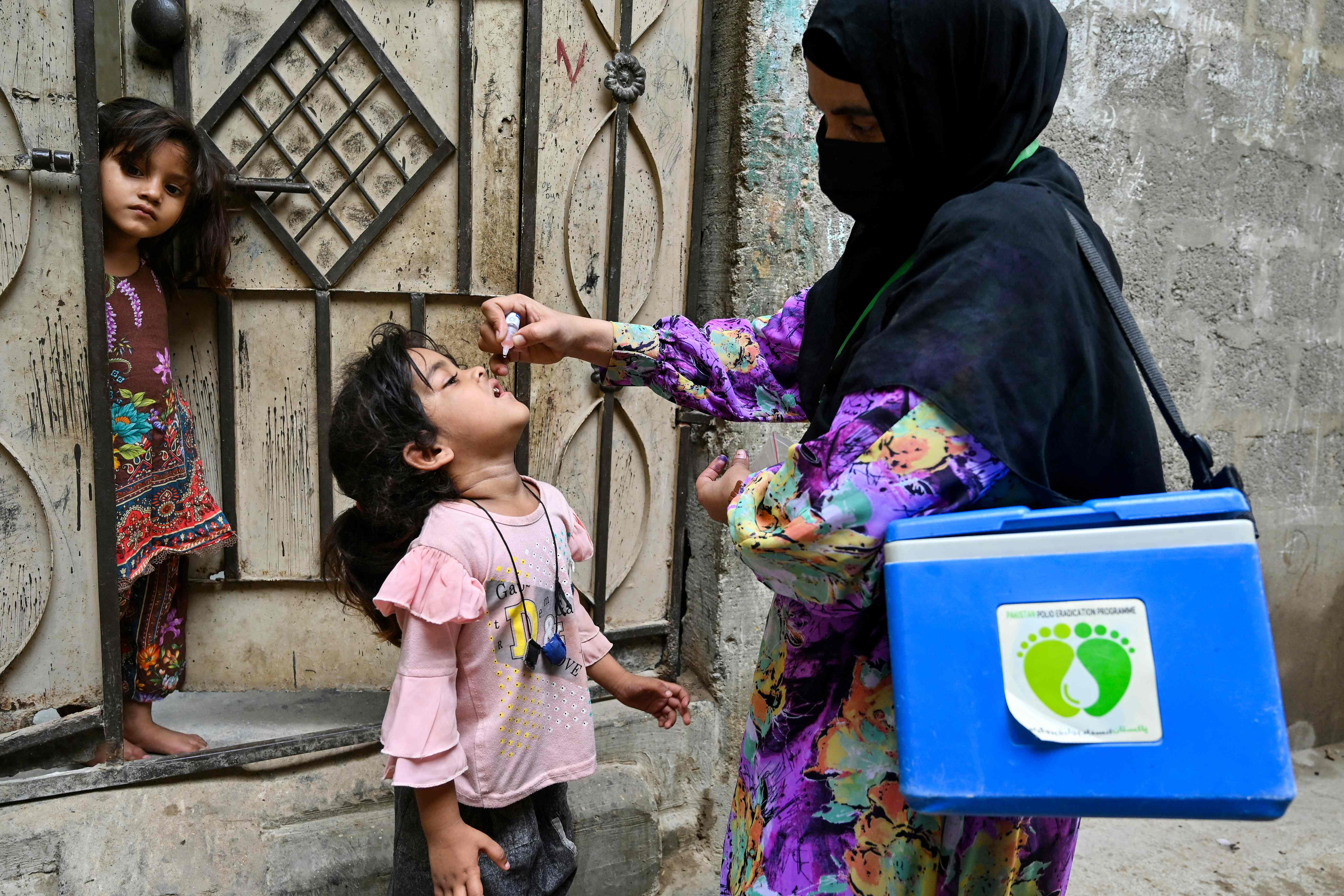 A health worker administers polio drops to a child for vaccination on the first day of a nationwide poliovirus eradication campaign in Karachi, Pakistan, on May 26, 2025. (AFP/File)