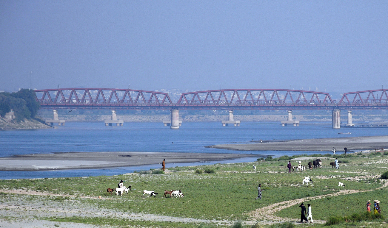 People walk next to a cultivated land on the dry riverbed of the Indus River in Hyderabad, Pakistan, on April 25, 2025. (REUTERS/File)