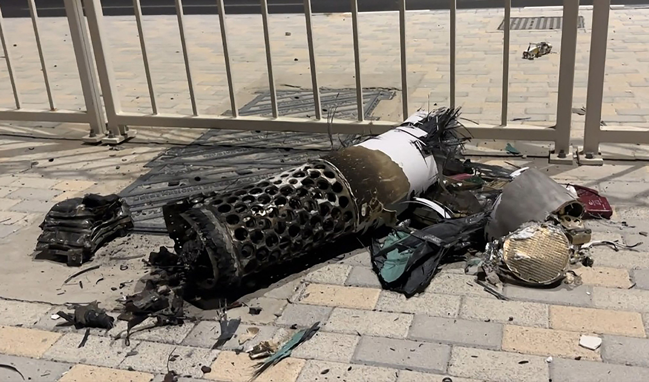 This frame grab taken from AFPTV footage shows the remnants of an Iranian missile intercepted over Qatar, as it lies on a pavement near a fence on June 23, 2025. (AFP)