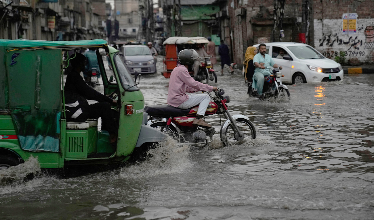 Motorists drive through a flooded road caused by heavy monsoon rains, in Lahore, Pakistan, on June 29, 2025. (AP)