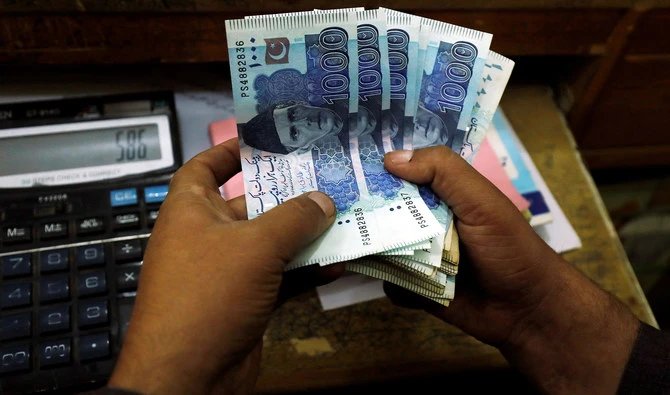 A trader counts Pakistani rupee notes at a currency exchange booth in Peshawar, Pakistan, on December 3, 2018. (REUTERS/File)