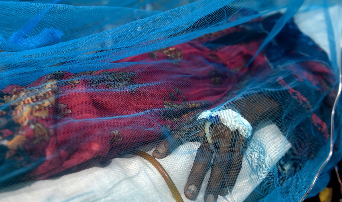 A patient suffering from dengue fever rests under a mosquito net at a hospital in Karachi on October 4, 2022. (AFP/File)