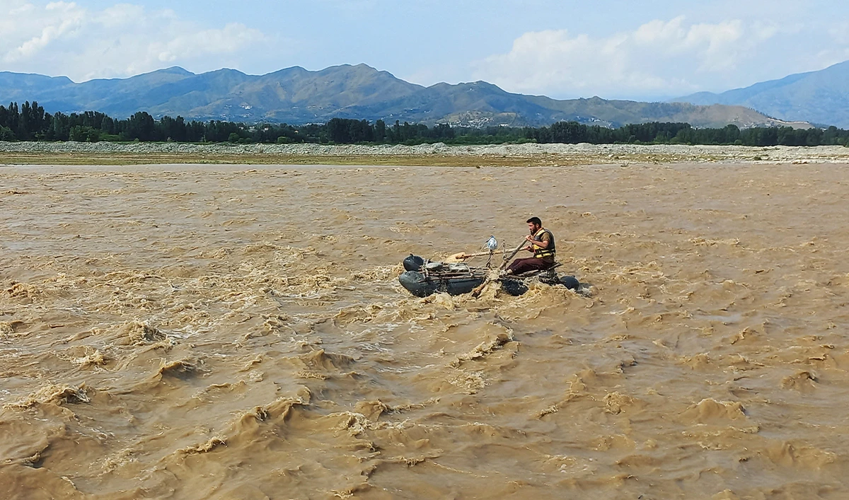 A rescue worker rows a raft while searching for survivors, after tourists, who were on a picnic, were swept away by overflowing floodwaters in the Swat River, in Swat Valley, in Pakistan, on June 27, 2025. (REUTERS)