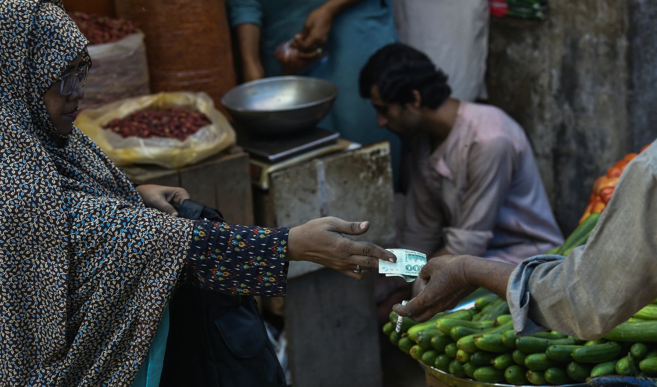 A customer buys vegetables from a stall at a market in Karachi on July 3, 2023. (AFP/ file)