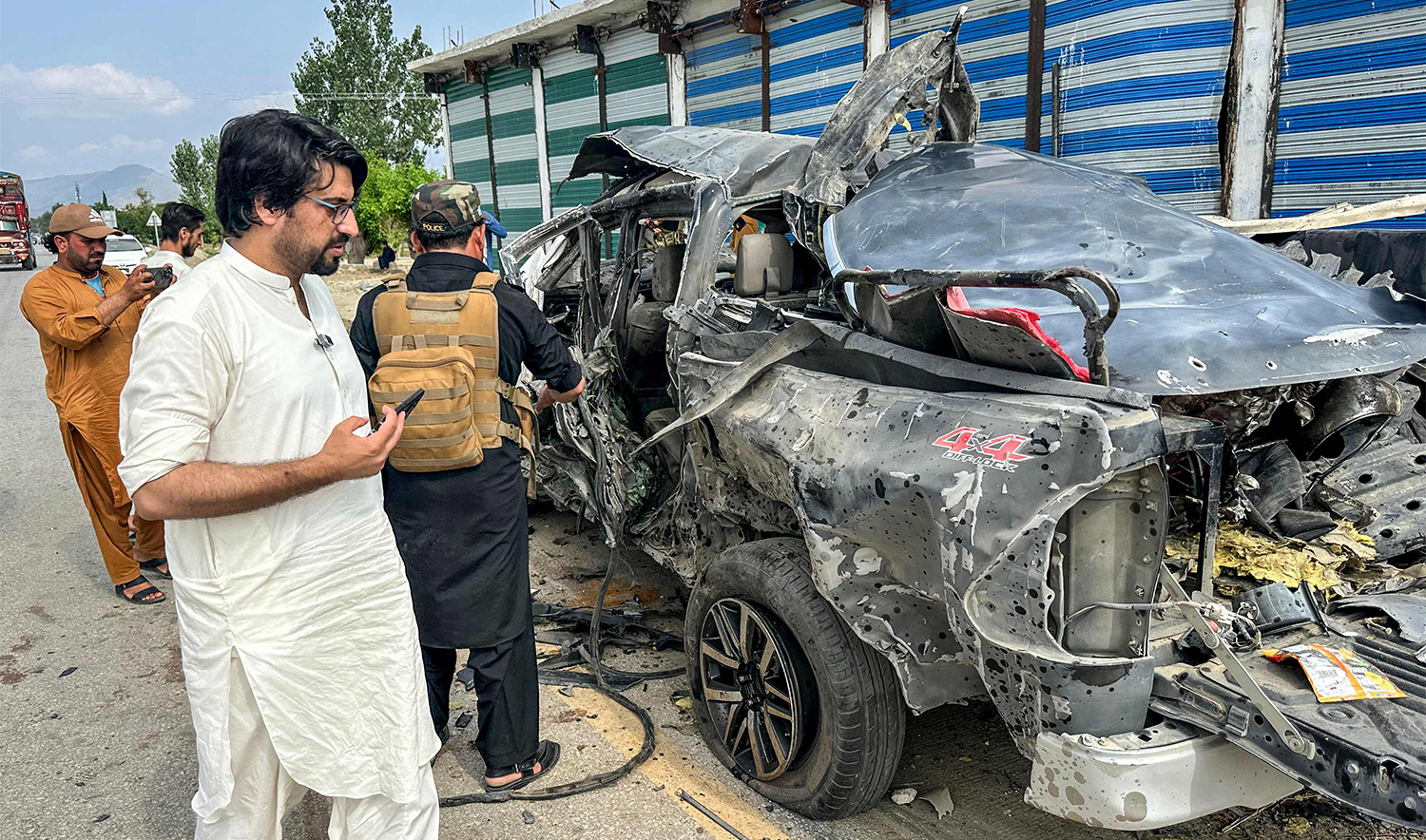 Local residents gather beside the wreckage of a vehicle after a blast in Bajaur, Khyber Pakhtunkhwa province, on July 2, 2025. (AFP)