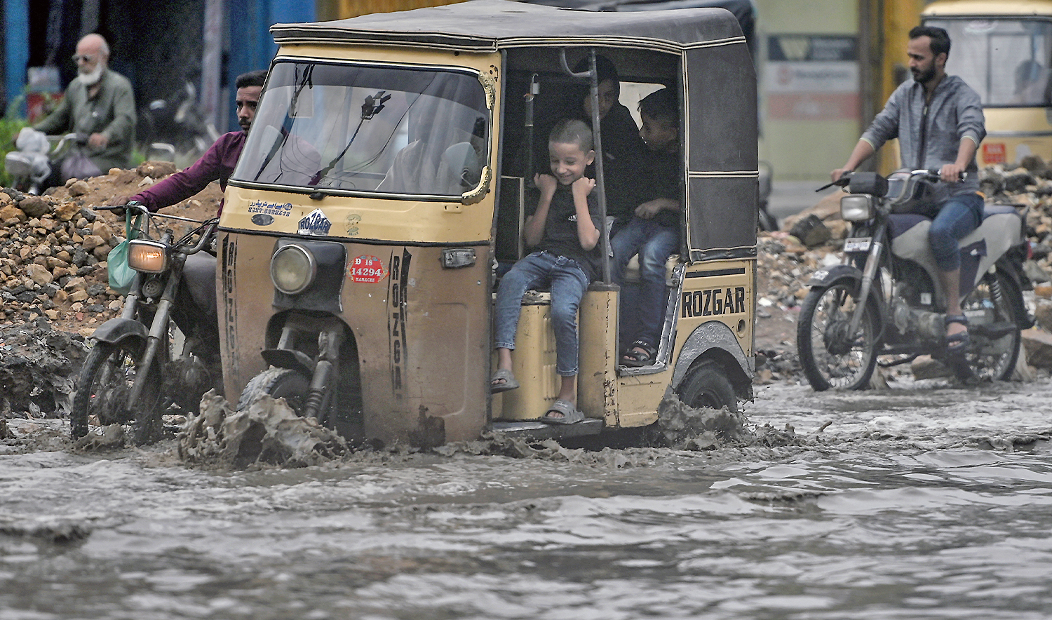 Commuters make their way through a flooded street after heavy rainfall in Karachi on June 28, 2025. (AFP/File)