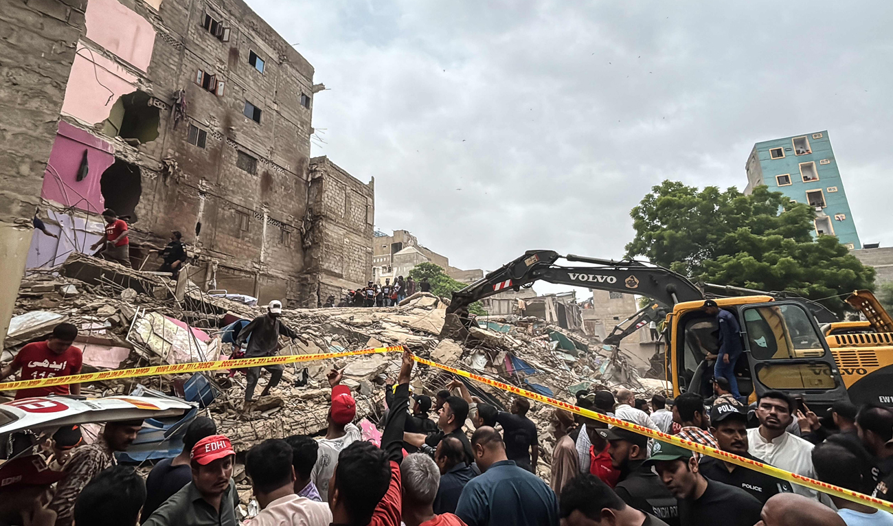 Rescuers search for victims in the rubble of a collapsed five-storey residential building in Karachi on July 4, 2025. (AFP)