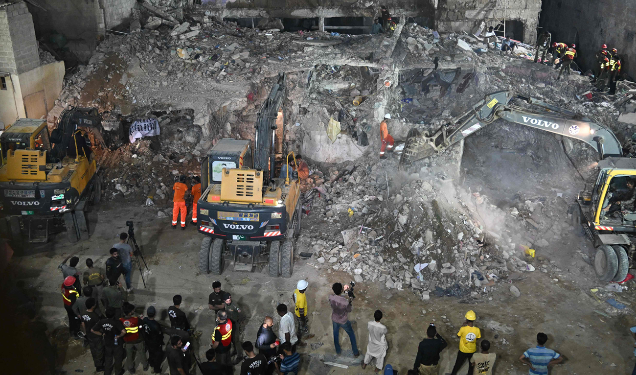 Rescue workers search for victims amidst the debris of a collapsed residential building in Karachi on July 4, 2025. (AFP)