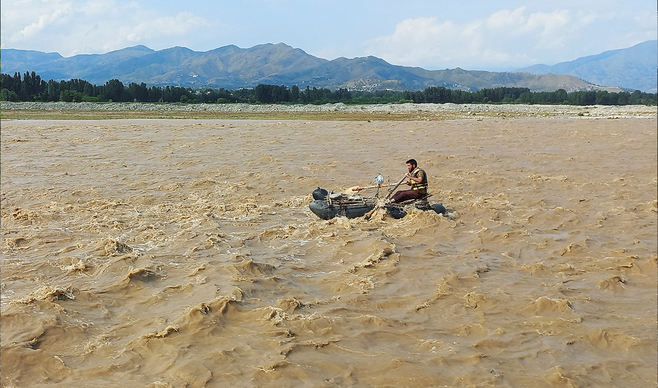 A rescue worker rows a raft while searching for survivors, after tourists, who were on a picnic, were swept away by overflowing floodwaters in the Swat River, in Swat Valley in Pakistan on June 27, 2025. (REUTERS/File)