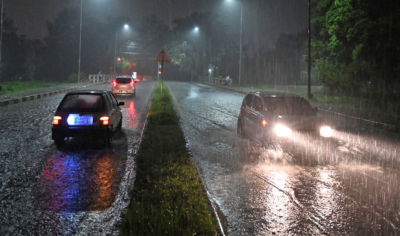 Commuters make their way through a flooded street during heavy rainfall in Islamabad on July 5, 2025. (AFP)