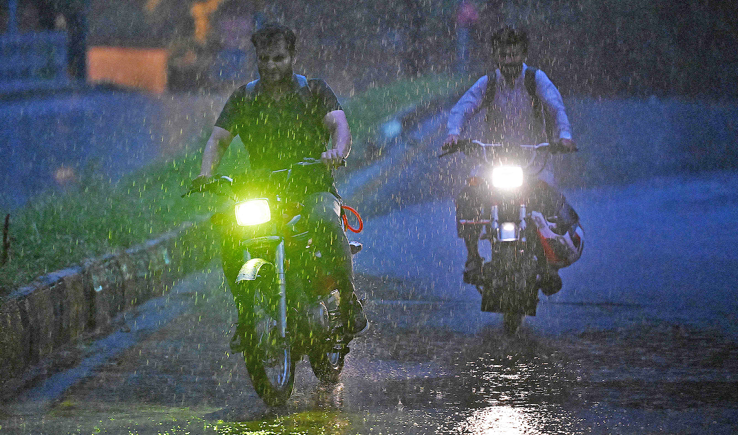 Motorists ride along a road amid heavy monsoon rains in Islamabad on July 9, 2025. (AFP)