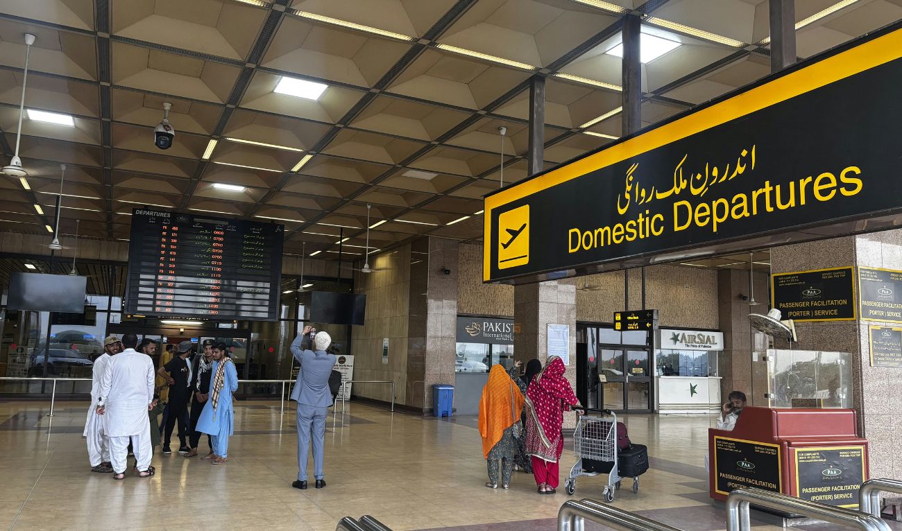 Passengers wait at Jinnah International airport after all domestic and international flights were cancelled in Karachi on May 7, 2025. (AFP)