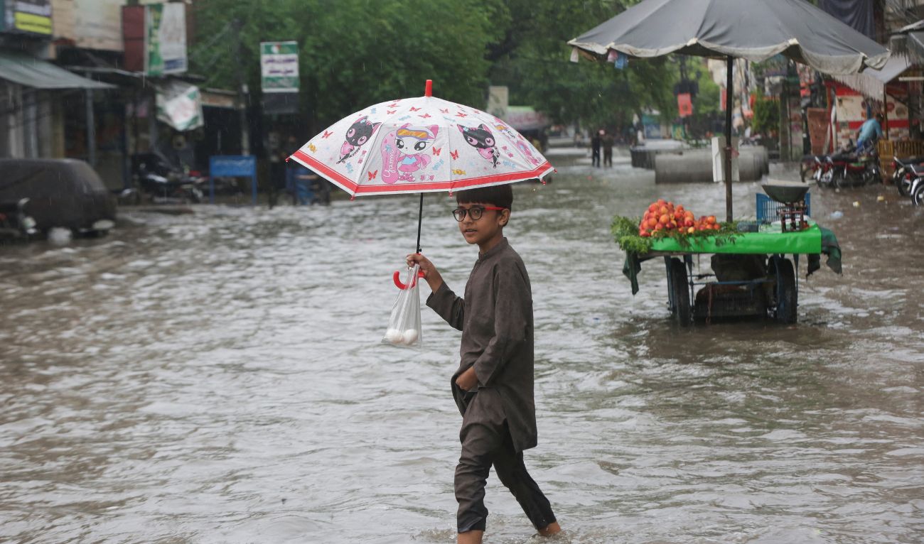 A Child holds an umbrella as he wades through a flooded street after a downpour in Lahore, Pakistan July 9, 2025. (REUTERS)