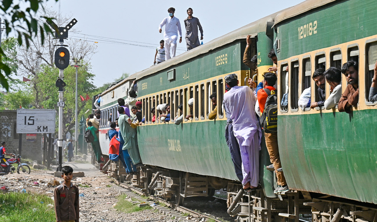 Passengers board a train at a railway station in Lahore on April 20, 2023, as they travel back home ahead of Eid al-Fitr festival marking the end of the holy fasting month of Ramadan. (AFP/File)